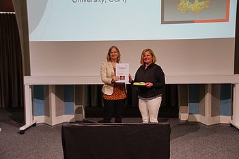 Frau Dr. Malgorzata Kowalik von der Pennsylvania State University, USA, erhält die Urkunde und den Preis für den ersten Platz im „Science meets Arts“-Wettbewerb, Foto: Herzog.
